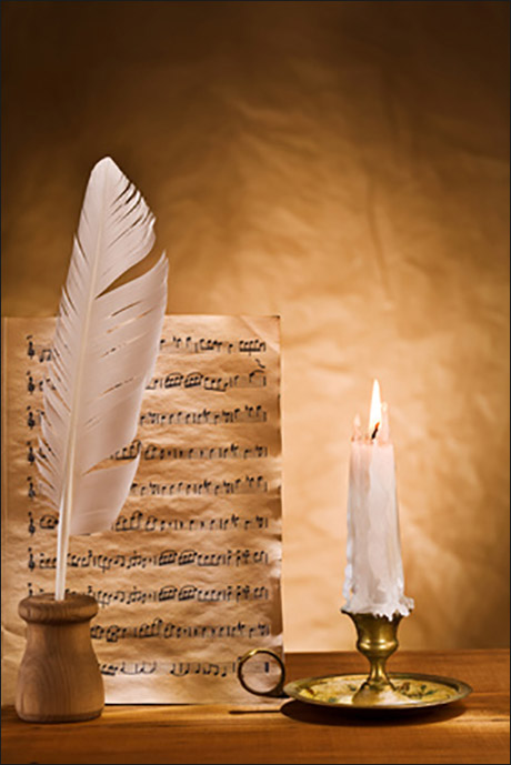 Notenblatt mit Feder und Kerze